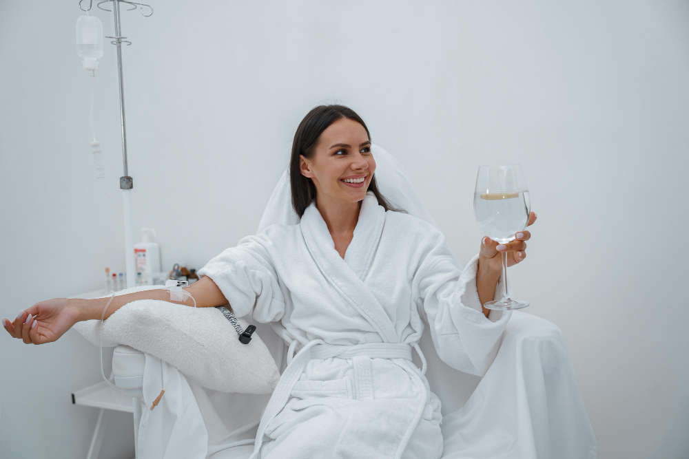 Spokojná klientka relaxuje v pohodlnom kresle počas aplikácie Infúzna terapia vitaminom C a dodržiava pitný režim v Aurel Clinic.