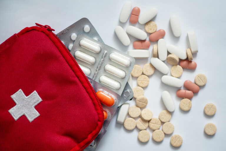 Prehľadne usporiadaná domáca lekárnička so základným zdravotníckym materiálom a liekmi pre bezpečnú prvú pomoc v domácom prostredí.